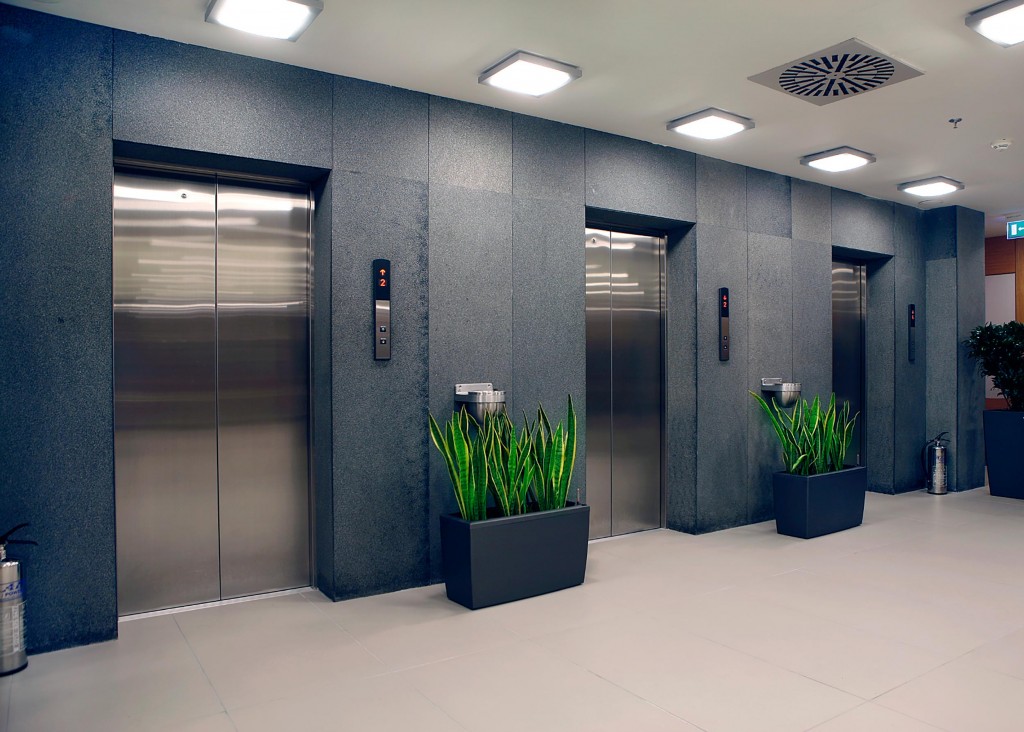 an image of three lifts within a modern office environment