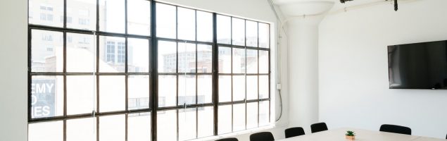 an image of a modern office interior with a large window and conference table