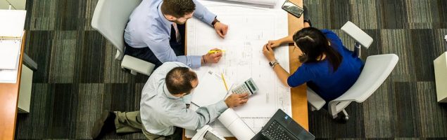 an image of a group of people sitting around a desk