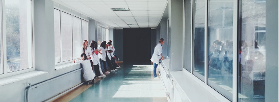 an image of a hallway in a hospital, which is light because of large windows and a light-colours suspended ceiling