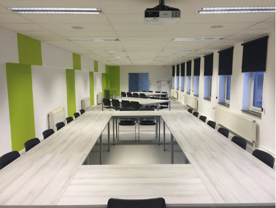 an image of a large office space with desks arranged in an oval-shape and a suspended ceiling to hide the ductwork of the interior