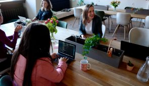 image of three women sitting on the chair using their laptops