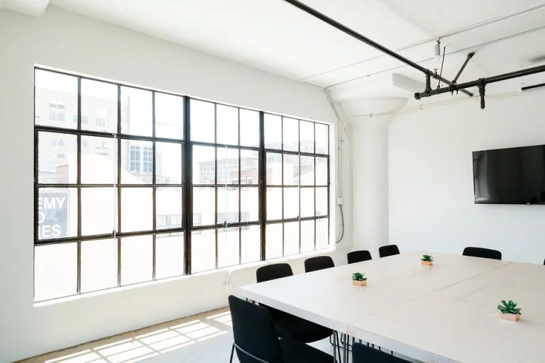 A modern conference room featuring a large window and a central table, showcasing an office refurbishments in Southampton.